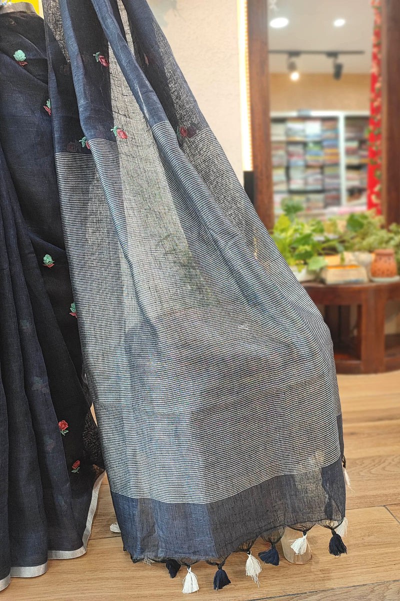 Navy Blue Pure Linen Saree with Multicolor Floral Embroidery, Silver Border & Checkered Pallu – Everyday Elegance with White-Black Tassels