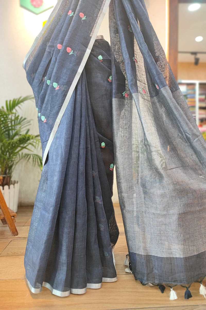 Navy Blue Pure Linen Saree with Multicolor Floral Embroidery, Silver Border & Checkered Pallu – Everyday Elegance with White-Black Tassels