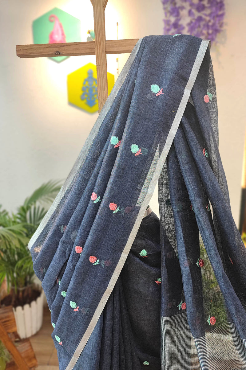 Navy Blue Pure Linen Saree with Multicolor Floral Embroidery, Silver Border & Checkered Pallu – Everyday Elegance with White-Black Tassels