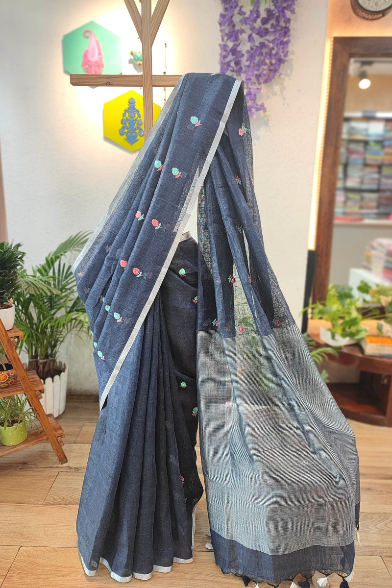 Navy Blue Pure Linen Saree with Multicolor Floral Embroidery, Silver Border & Checkered Pallu – Everyday Elegance with White-Black Tassels